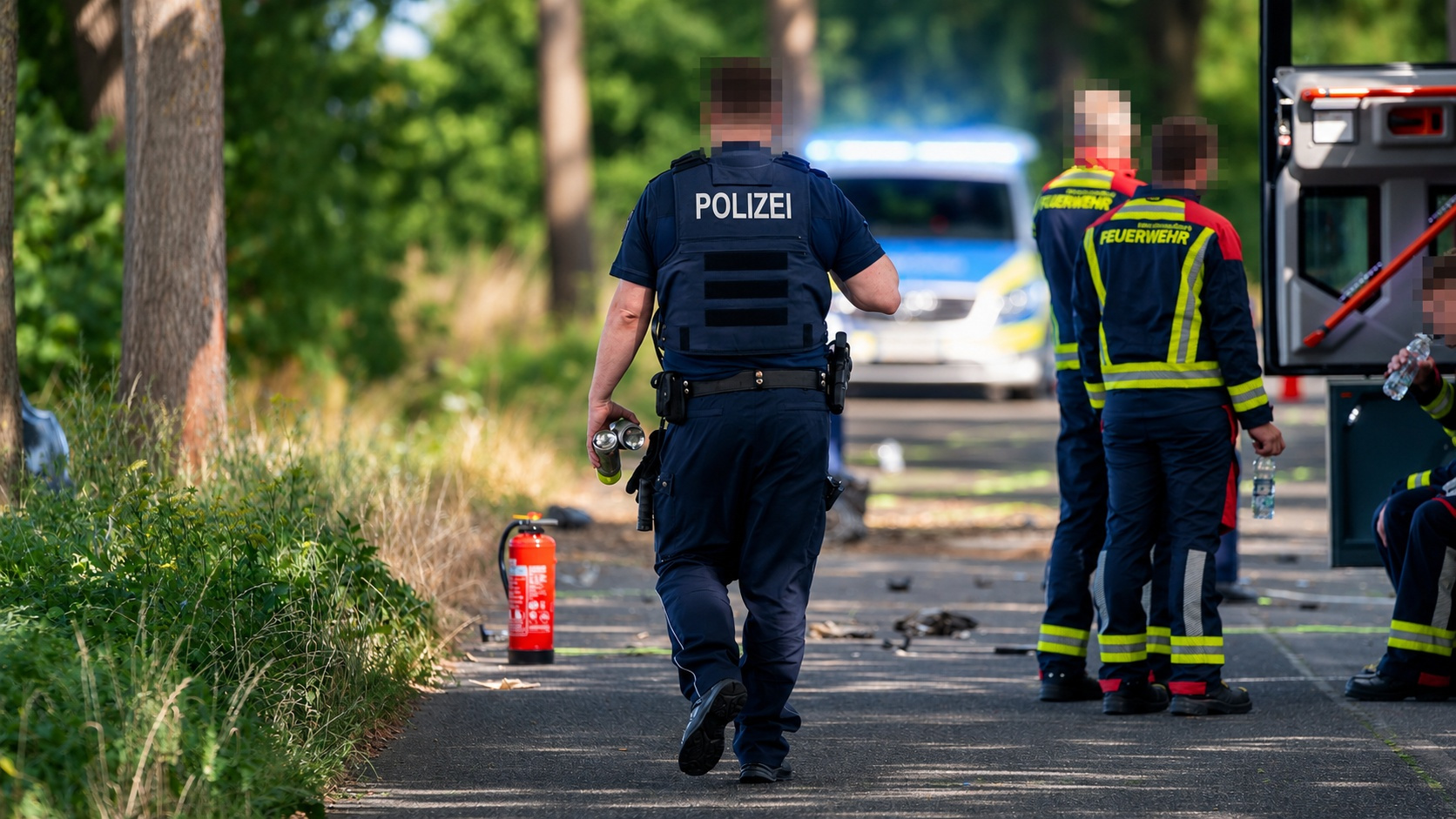 wide_outdoor_emergency_scene_on_a_tree_lined_road