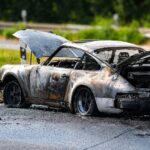 Brennender Pkw an der Anschlussstelle der A61 in Wickrath Richtung Venlo während eines Feuerwehreinsatzes.