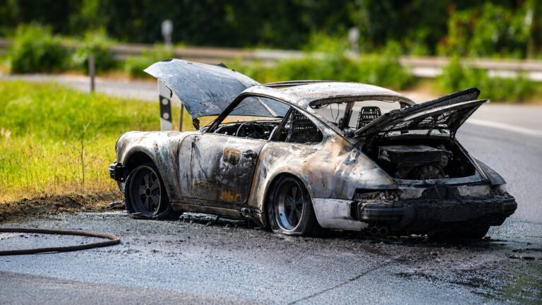Brennender Pkw an der Anschlussstelle der A61 in Wickrath Richtung Venlo während eines Feuerwehreinsatzes.
