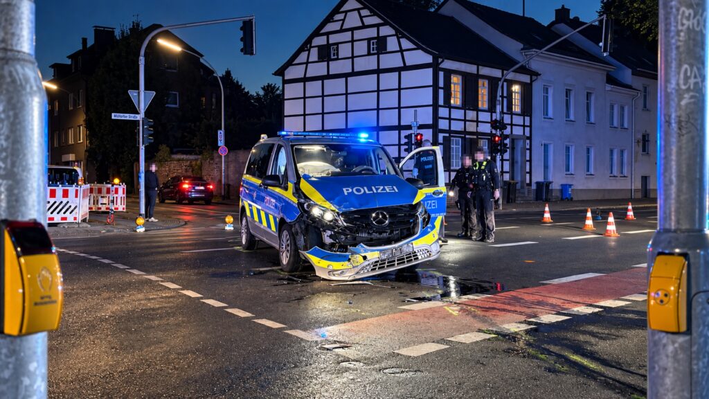 : Beschädigter Streifenwagen nach einem Verkehrsunfall zwischen zwei Streifenwagenteams in Rheydt. An der Fahrzeugseite sind deutliche Unfallschäden und ausgelöste Airbags zu sehen.