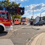 Unfallstelle in Mönchengladbach-Lürrip: Beschädigte Fahrzeuge an einer Kreuzung mit Polizeiabsperrung.